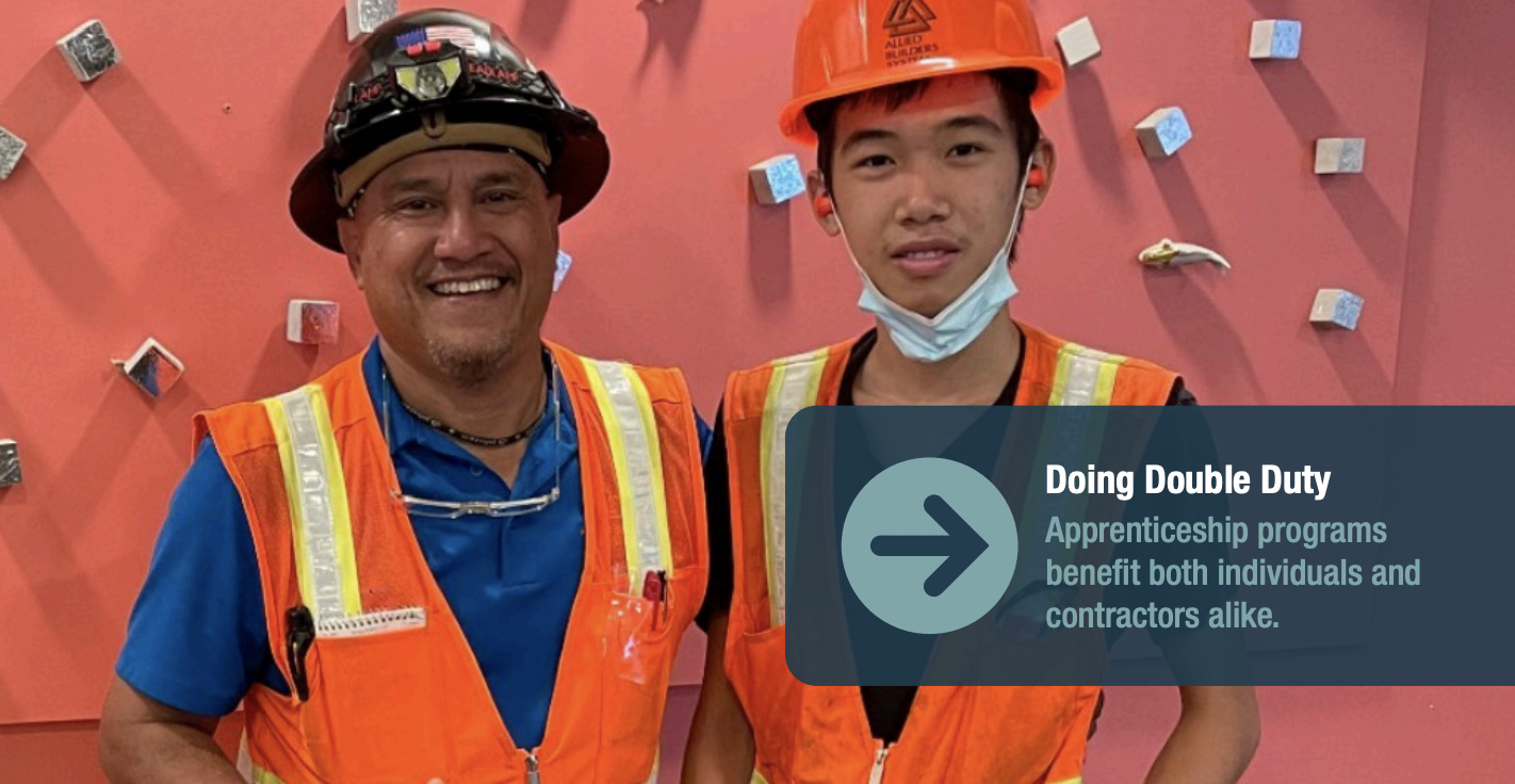 A summer intern poses with his site manager in front of an orange background.